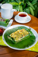 Grilled rice with shredded chicken and green chilies, wrapped in banana leaves, traditional Indonesian food