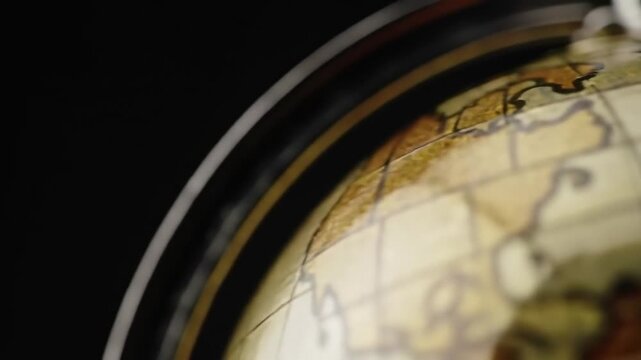 Golden globe with ring on black background