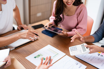 group of colleagues in formal clothing discussing business ideas while gathering at table in modern...