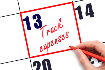 13 th day of the month.  Hand writing Track expenses reminder and drawing red frame on calendar with red pen on white background. Business concept. Planning and scheduling