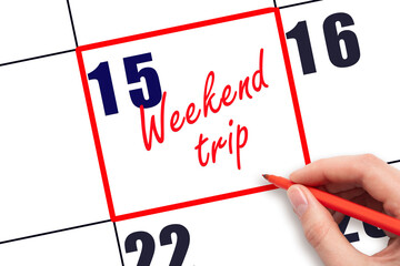 15 th day of the month.  Hand writing Weekend trip reminder and drawing red frame on calendar with red pen on white background. Business concept. Travel concept. Planning and scheduling
