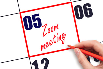5 th day of the month.  Hand writing Zoom meeting reminder and drawing red frame on calendar with red pen on white background. Business online concept. Planning and scheduling