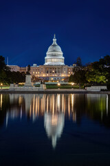 Obraz premium The illuminated United States Capitol in Washington DC at night with the famous reflection pool