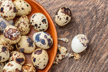 Fototapeta premium Top view of quail eggs in wooden plate on table