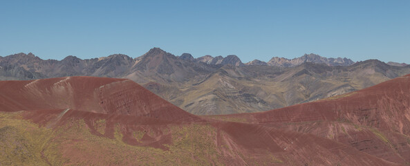 Bright brown with a bit of greenery mountains and totally different color mountains in the back