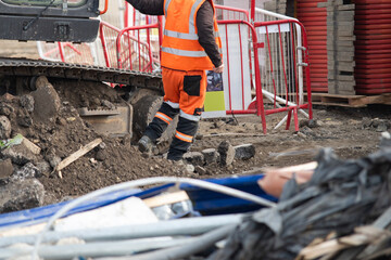 Excavator driver next to his machine on construction site