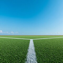 Obraz premium Green Sports Field with Clear Blue Sky and White Line Dividing Surface
