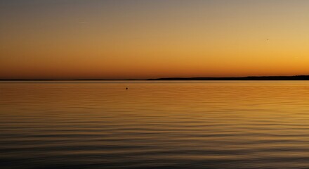 Obraz premium Calm Water Reflections at Colorful Sunset Over Horizon