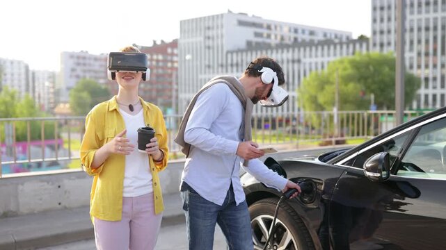 A couple wearing VR headsets while their electric vehicle charges, showcasing modern technology and sustainable transportation.