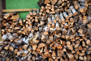 A stack of firewood in a woodshed outside