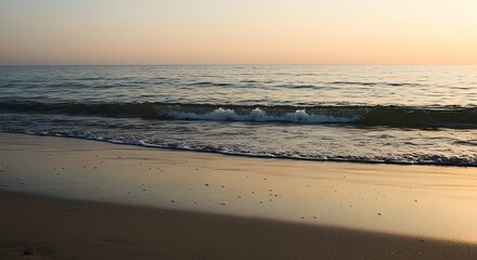 Fototapeta premium Ocean Wave Gently Rolling Onto Sandy Beach at Sunset
