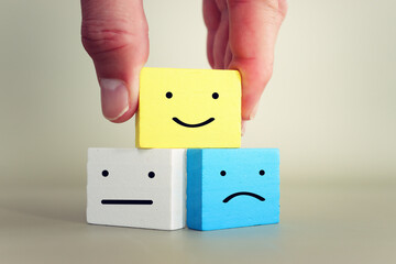 Wooden cubes with happy and sad face. concept of happiness, emotion and satisfaction