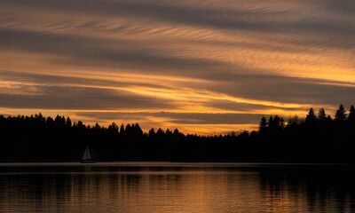 Fototapeta premium Sailboat on Lake at Sunset with Colorful Sky and Forest Silhouette