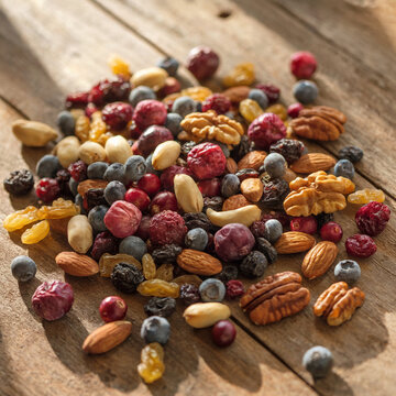 El snack de energ&iacute;a: Un vibrante mix de frutos secos y bayas sobre una mesa r&uacute;stica