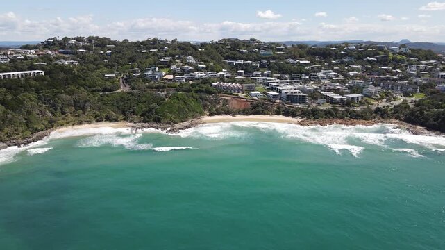 High drone aerial overseeing Coolum Beach on a sunny day with blue water