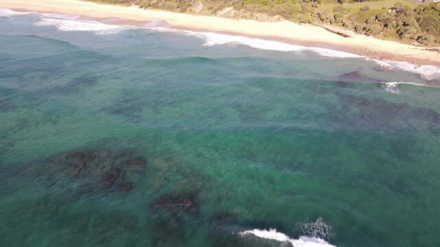 Drone aerial moving forward and rising over coolum beach and mount coolum