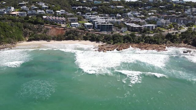 Drone aerial moving down towards Coolum Beach in Australia on a sunny day