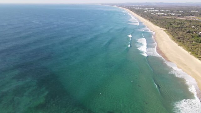 Drone aerial panning over beautiful blue beach in coolum on a sunny day