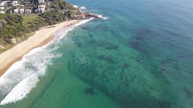 Drone aerial over clear blue water in coolum beach on a sunny day