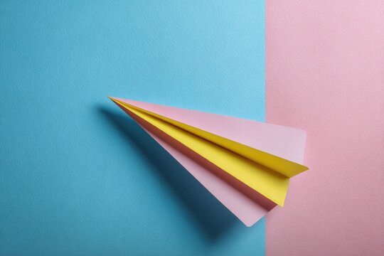 Paper airplane, pastel colors, geometric composition, split background, minimalist, studio shot - Powered by Adobe