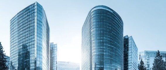 Modern glass skyscrapers against a bright sky, showcasing architectural design