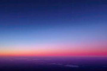 Fototapeta premium A vertical image captures a vibrant gradient sky transitioning from dark blue to pink and purple