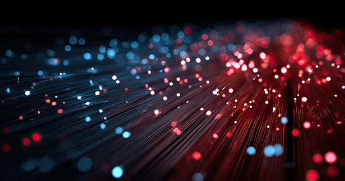 A close-up view of glowing fiber optic strands in blue and red, symbolizing data transmission