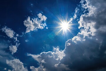 Vivid, upward-angle shot of a radiant sun shining through fluffy white clouds in a deep blue sky