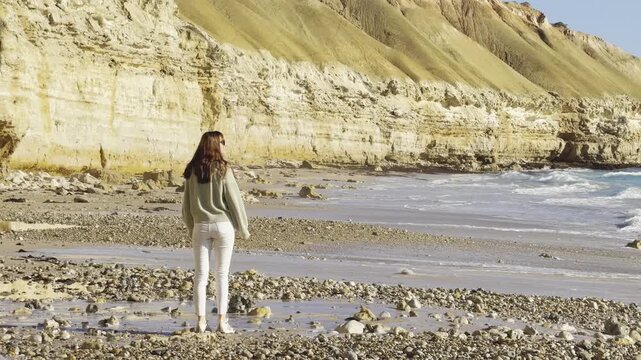happy girl walks and admires beautiful Port Willunga Beach with turquoise water and tall white cliffs on a sunny day, Gulf St Vincent, Fleurieu Peninsula, Adelaide, South Australia