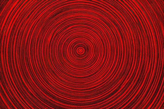 Concentric red circles radiating outward, creating a mesmerizing optical illusion on a dark background