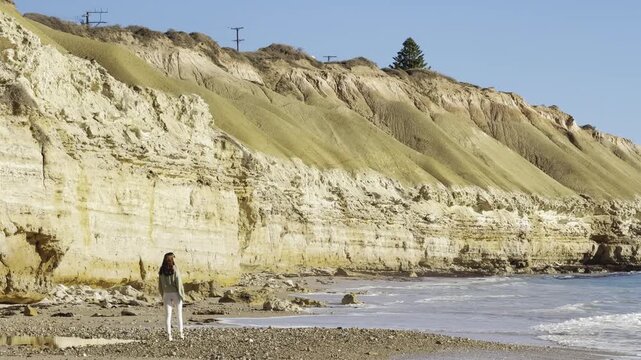 happy girl walks and admires beautiful Port Willunga Beach with turquoise water and tall white cliffs on a sunny day, Gulf St Vincent, Fleurieu Peninsula, Adelaide, South Australia