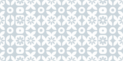 Seamless pattern of geometric flowers and circles in white on a light blue background