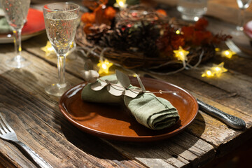 Fall tablescape, autumn table setting. Thanksgiving gathering setup. Plates featured with decorated napkins. 
