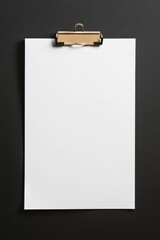 Minimalist composition of blank white paper sheet on black background with golden clip for design mockup