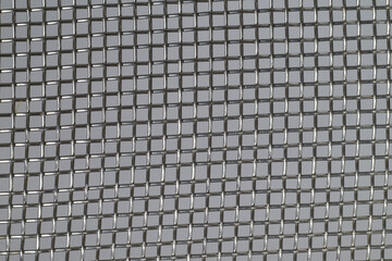 Close-up of metallic wire mesh texture on a gray background
