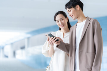 デート中にスマホを見る若いカップル