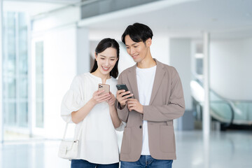 デート中にスマホを見る若いカップル