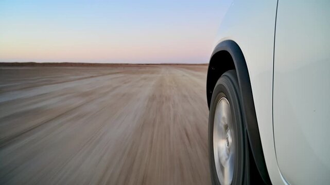 Low angle view of the wheel of an SUV as it drives through the Karakum Desert in Turkmenistan
