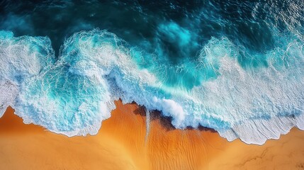 Aerial view of powerful turquoise ocean waves crashing onto a golden sandy beach creating white foamy surf