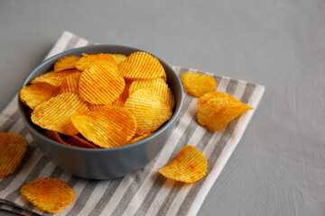 Crinkle Potato Chips with Chorizo Sausages and Onions Flavor in a Bowl, side view. Copy space.