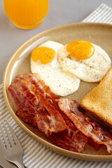 Homemade American Bacon Egg and Toast Breakfast on a Plate, side view.