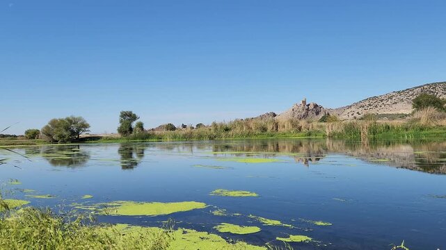 In Osmaniye Turkey, Amouda castle (Hemite kalesi), stands majestically above Ceyhan river, its ancient stone walls and towers reflected in calm waters, creating a serene and picturesque scene in fall