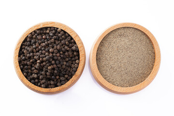 Black peppercorns and ground black pepper powder on white background	