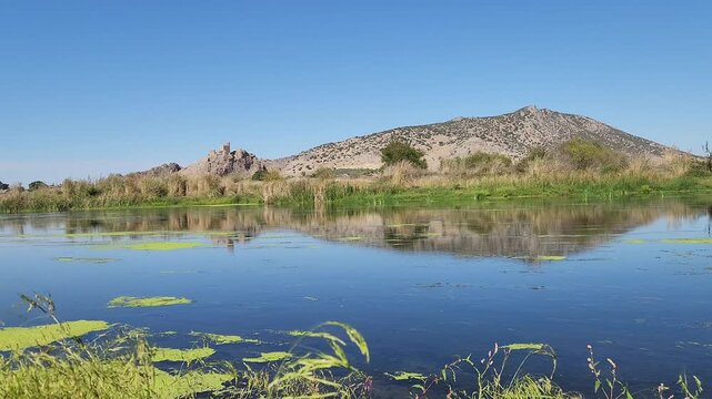 In Osmaniye Turkey, Amouda castle (Hemite kalesi), stands majestically above Ceyhan river, its ancient stone walls and towers reflected in calm waters, creating a serene and picturesque scene in fall
