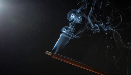 Fototapeta premium Aromatic smoke delicately rises from a glowing incense stick, creating a serene and captivating atmosphere against a dark background, perfect for meditation, relaxation, and spiritual calm
