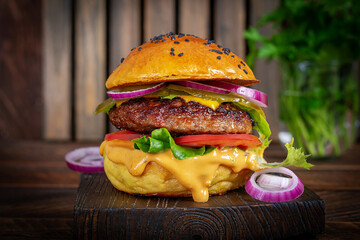 Beef hamburger. Sandwich with beef burger, tomatoes, cheese, pickled cucumber and red onions. Cheeseburger