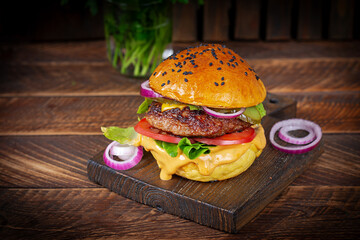 Beef hamburger. Sandwich with beef burger, tomatoes, cheese, pickled cucumber and red onions. Cheeseburger