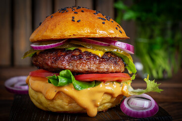 Beef hamburger. Sandwich with beef burger, tomatoes, cheese, pickled cucumber and red onions. Cheeseburger
