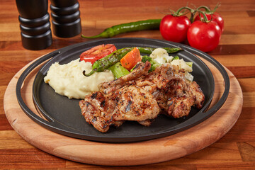 Grilled Chicken Chop Served with Sautéed Vegetables, Mashed Potatoes, Tomato and Pepper – Close-Up