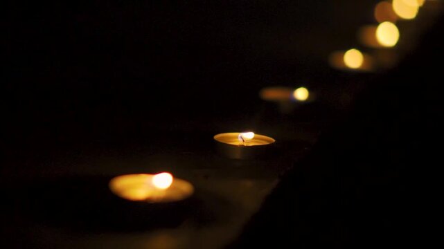 Close up shot of illuminating Diyas in row. Lit Diya in dark night background. Happy Diwali background. Diwali decoration in Indian home. Diwali is festival of lights and happiness
